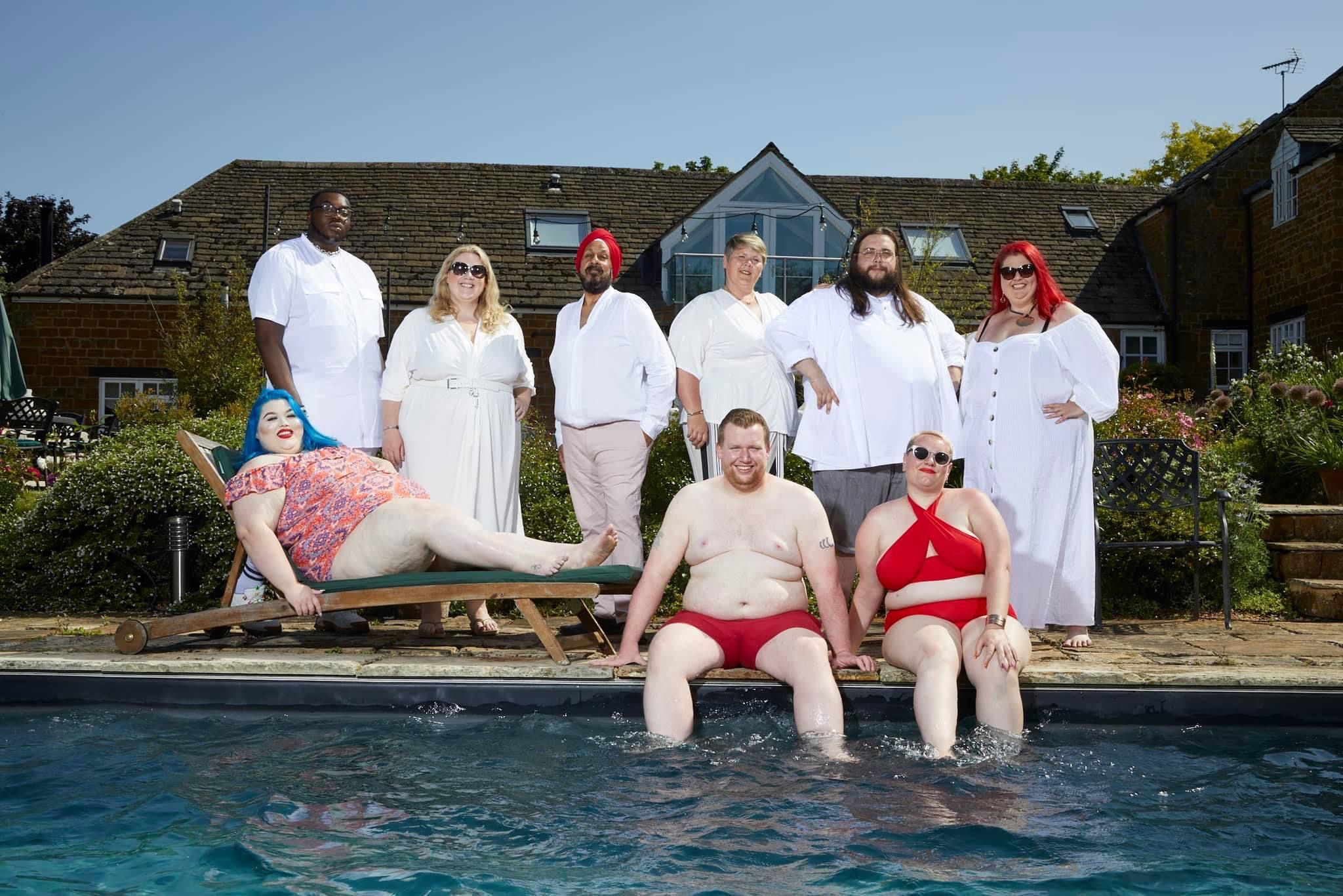A group of obese people posing for a picture by a pool